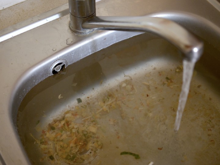 blocked sink full of food scraps